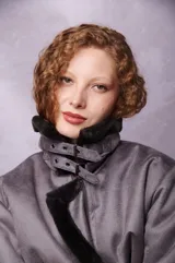 Campera gris oscuro con cuello alto con solapa y cierre con hebillas.