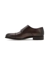 Zapato tipo Monk Strap de cuero color marrón oscuro, con doble hebilla metálica plateada y puntera reforzada.