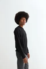 Remera de manga larga, color negro, con cuello redondo y corte recto.