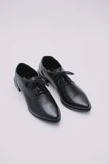 Zapato acordonado de cuero color beige con taco de madera de 3 cm.