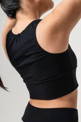 Top deportivo negro de algodón elastizado, con faja ancha doble y breteles anchos. Presenta detalle de puntilla en el escote y espalda entera.