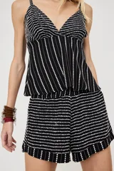 Short negro con diseño de líneas y puntos blancos bordados, corte holgado y volados en el ruedo.
