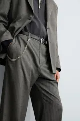 Pantalón de vestir con corte flare y ajuste relajado, confeccionado en tejido con viscosa y patrón de espiga. Cuenta con bolsillos frontales, bolsillos traseros de vivo y cierre frontal con cremallera y botón.