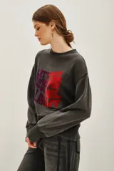 Buzo de cuello redondo y manga larga, confeccionado en algodón y viscosa con efecto lavado. Presenta un estampado frontal con tipografía en tonos degradados de violeta a rojo.