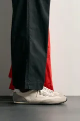 Zapatilla estilo retro de cordones, con parte superior en combinación de piezas textiles y detalles de piel, en tonos beige y gris con suela a tono.