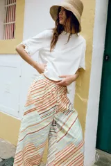 Camiseta blanca de manga corta y cuello redondo, confeccionada en hilatura de algodón con detalle de aplicación de encaje a tono en las mangas y los laterales.