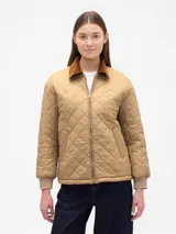 Campera puffer acolchada con diseño de rombos, color beige, con cuello de pana en tono marrón y puños elásticos.