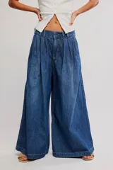 Pantalón wide leg de denim azul con diseño sastre, tiro bajo y pinzas frontales.