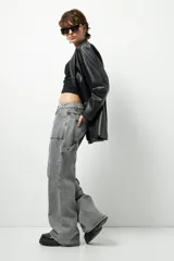 Jean de corte carpenter, estilo wide leg y tiro bajo, en color gris lavado. Presenta diseño de bolsillos frontales tipo parche y costuras reforzadas.