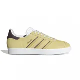 Championes adidas modelo Gazelle, confeccionados en gamuza color amarillo con las icónicas tres tiras laterales en marrón. Presentan suela de goma blanca, lengüeta blanca y detalle en el talón en color marrón oscuro.