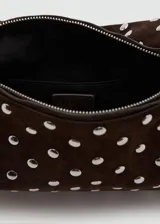Bolso de hombro tipo baguette confeccionado en piel bovina color marrón oscuro, con diseño estructurado y superficie decorada con tachas metálicas plateadas distribuidas uniformemente. Cuenta con cierre superior y asa integrada.