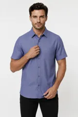Camisa azul melange de manga corta, con cuello clásico, cierre frontal con botones y un bolsillo ojal en el pecho.