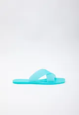 Sandalia chata de goma semi transparente color gris, con doble tira entrelazada sobre el empeine.