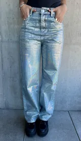 Pantalón de jean celeste con estampado de cuadrados plateados reflectantes.