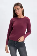 Remera de manga larga confeccionada en tejido rib con efecto lavado, de corte ajustado y cuello redondo.