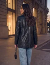 Blazer de eco cuero negro, con solapa clásica, cierre frontal con botones y bolsillos aplicados.