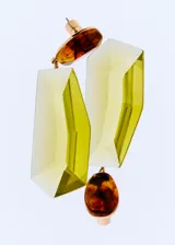 Aros colgantes con diseño geométrico, compuestos por piezas de resina facetada en color verde lima y detalles de resina marmolada en tonos ámbar, unidos por herrajes metálicos dorados.