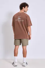 Remera de algodón color marrón con efecto lavado, corte oversize y estampa pequeña en el pecho.
