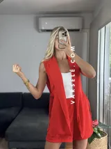 Conjunto color naranja compuesto por un chaleco sin mangas con solapas y un short de tiro alto con elástico en la parte trasera.