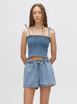Short de denim azul claro con corte relajado, cintura elástica con cordón ajustable y bolsillos laterales.