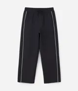 Pantalón deportivo de corte recto y estilo holgado, color negro con una línea vertical blanca en los laterales. Cuenta con cintura elástica con cordón de ajuste y bolsillos laterales.