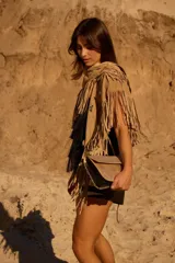 Chall de gamuza natural con diseño de flecos largos en todo el borde y detalle de pins metálicos decorativos en la parte frontal.