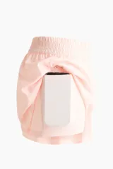 Pantalón corto de deporte de doble capa, color rosado, con corte estándar, cintura elástica fruncida y mallas interiores.