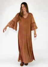 Vestido largo color tostado, con escote en V, mangas largas acampanadas con volados en capas y diseño holgado.