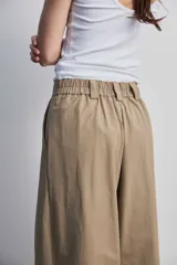Pantalon de pierna ancha y tiro alto color marron, con bordado en contraste que recorre el ruedo y detalles en calado.