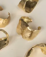 Brazalete rígido plateado con textura irregular.