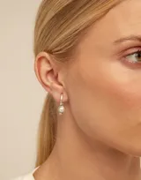 Dije de piercing dorado con forma circular y cristal celeste.