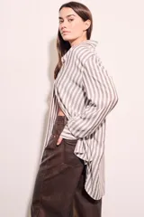 Camisa oversize a rayas verticales color beige y blanco, de mangas largas y corte holgado.