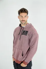 Hoodie de algodón con efecto lavado, color bordó, con capucha ajustable mediante cordones negros, bolsillo frontal tipo canguro y estampa rectangular con logo en el pecho.