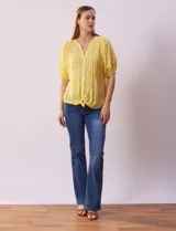 Blusa amarilla estampada con cuello en V, manga corta con volados y ruedo anudado.