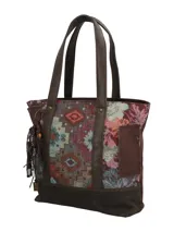 Cartera tipo tote con diseño patchwork que combina paneles de tejido con motivos geométricos y florales, con detalles en cuero sintético marrón en la base y las asas. Incluye un llavero decorativo con borlas y cuentas colgando de una de las asas.