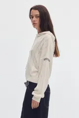 Hoodie cropped de punto color marfil con tejido de ochos, capucha con cordón ajustable y mangas largas.