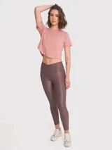 Calza deportiva de tiro alto con cintura en forma de V, confeccionada en tela brillante con acabado efecto cuero. Presenta un diseño ajustado de largo al tobillo.