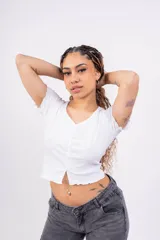 Remera corta de punto canalé color rosa, con escote en V, mangas cortas con volados y cierre frontal con botones.