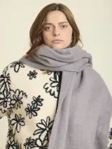 Bufanda rectangular de tejido suave color gris.