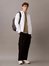 Remera de algodón con cuello redondo y manga corta, color beige. Presenta un estampado frontal con el logo de Calvin Klein y la inscripción New York en estilo cursivo.