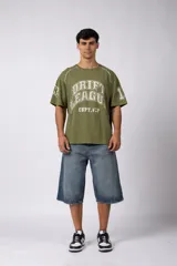 Remera de algodón color verde oliva con diseño de estilo deportivo y urbano. Presenta un estampado frontal con la inscripción 'DRIFT LEAGUE' y detalles de costuras blancas en los hombros. Tiene un corte holgado y mangas cortas.