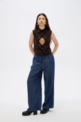 Chaleco de punto sin mangas con cuello polo, diseño de rombos estilo argyle en tonos marrón, negro y beige.