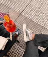 Championes plateados de cuero, con detalles en beige y suela color crema.