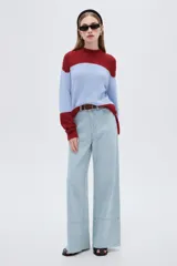 Sweater de punto holgado con cuello alto, diseño multicolor de bloques en tonos bordó, celeste y rojo, de manga larga.