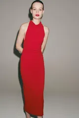 Vestido largo negro de cuello halter fluido, con detalle de drapeado lateral y espalda descubierta.