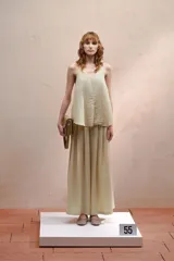 Top color beige claro, sin mangas, con tiras finas hacia el cuello y espalda descubierta que se cierra con dos lazos ajustables.