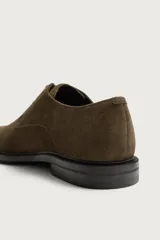Zapato de cordones tipo derby para hombre, fabricado en piel con acabado en serraje de color azul marino, con horma redonda y suela a contraste.