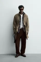 Parka relaxed fit de tejido técnico ligero, color verde militar, con cuello subido, manga larga y bolsillos de plastrón con solapa en la cadera. Cuenta con cintura ajustable con cordones y cierre frontal con cremallera oculta por solapa con botones a presión.