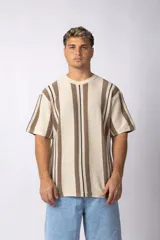 Remera de manga corta con textura tejida, cuello redondo y diseño de rayas verticales en tonos beige, marrón y negro.