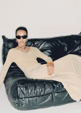 Vestido midi de diseño combinado con cuerpo de punto acanalado en color beige, cuello en pico y manga larga. La falda es de corte evasé con diseño de tablas, trabillas y cinturón desmontable con hebilla metálica.